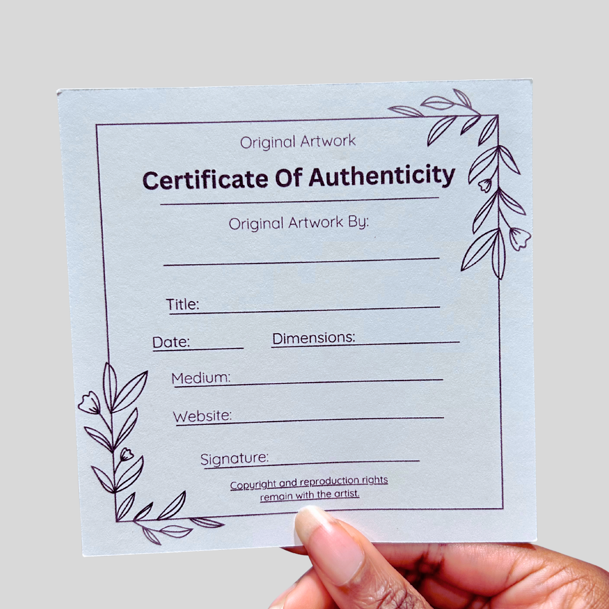 Certificate of Authenticity for original artwork held by a hand on a light gray background